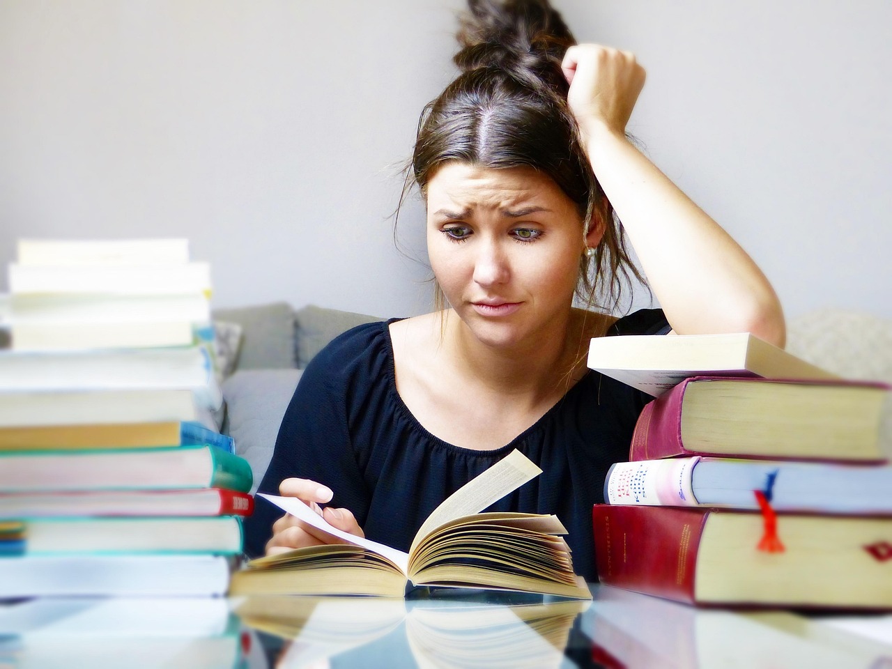 TTLL_blog_problema-aprender_main Mujer tratando de aprender idiomas mediante la lectura de manuales y libros de texto, se desespera al no conseguirlo