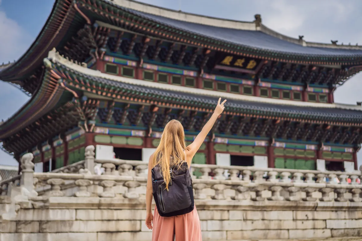 vocabulario-viajar-coreano Chica viaja a Corea del Sur y posa delante de un monumento
